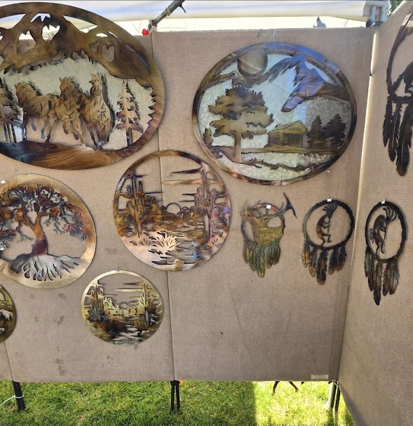 Handcrafted metal artwork and dreamcatcher-style pieces displayed at Riverfest.