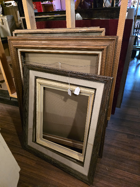 Selection of empty vintage picture frames at a thrift store.