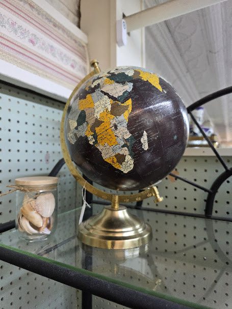Vintage tabletop globe displayed inside a thrift store.