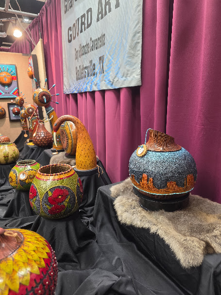 Colorful hand-carved and painted Southwestern gourd art displayed by an artist at the Ruidoso Art & Wine Festival.