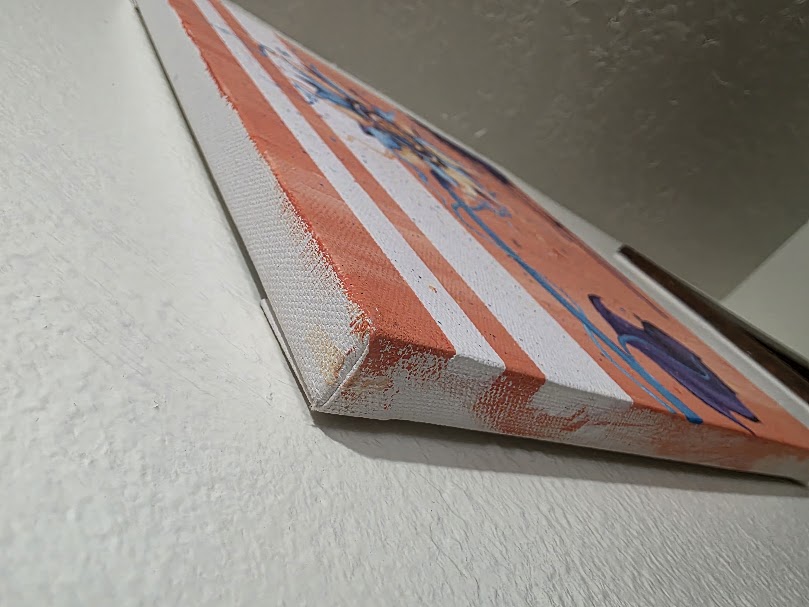 Side view of a stretched canvas showing paint wrapped around the edge of the original artwork.